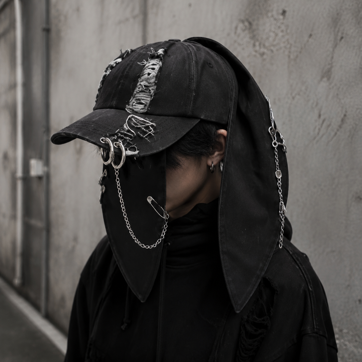 Black bunny-ear chain cap worn with dark streetwear