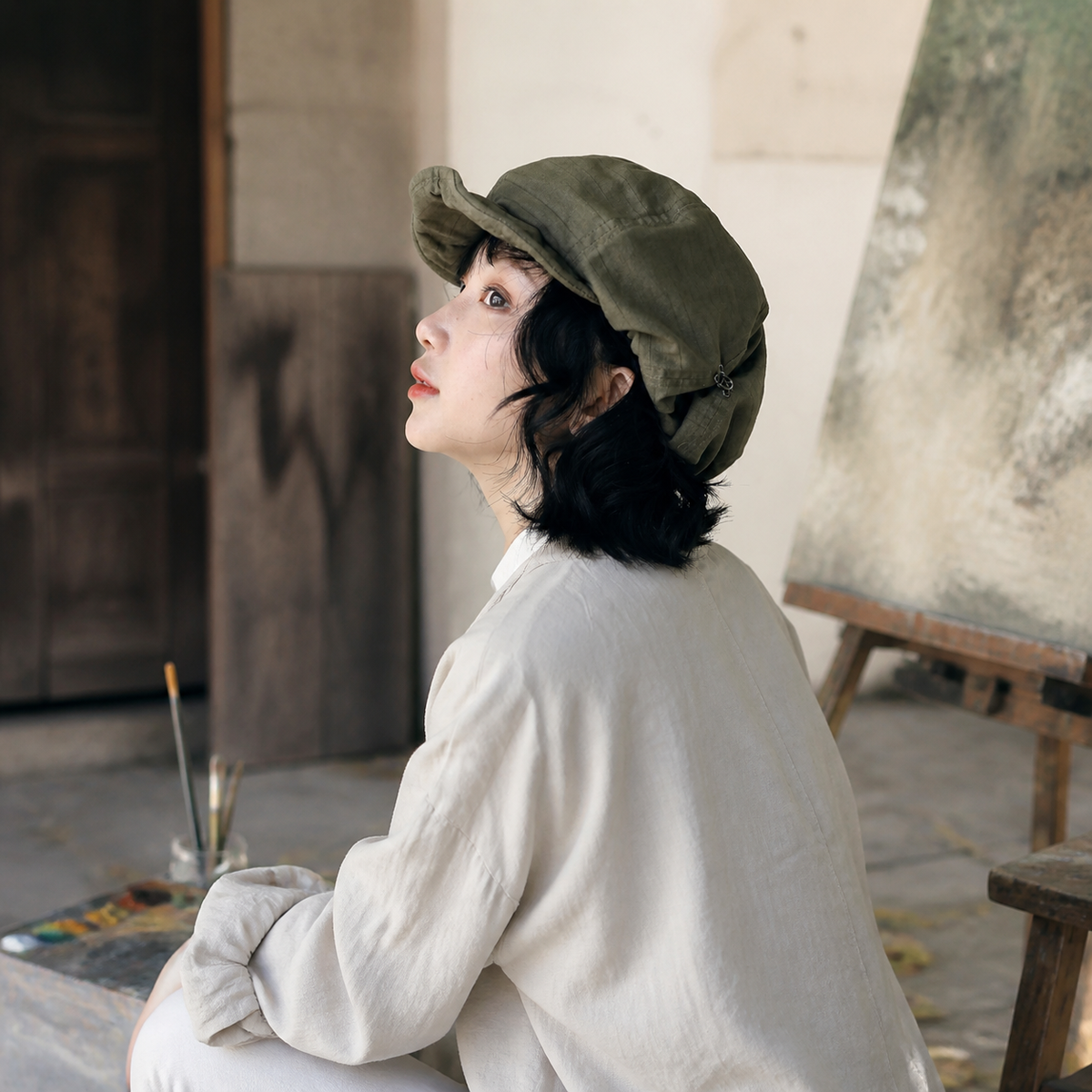 Olive painter beret worn in an art studio