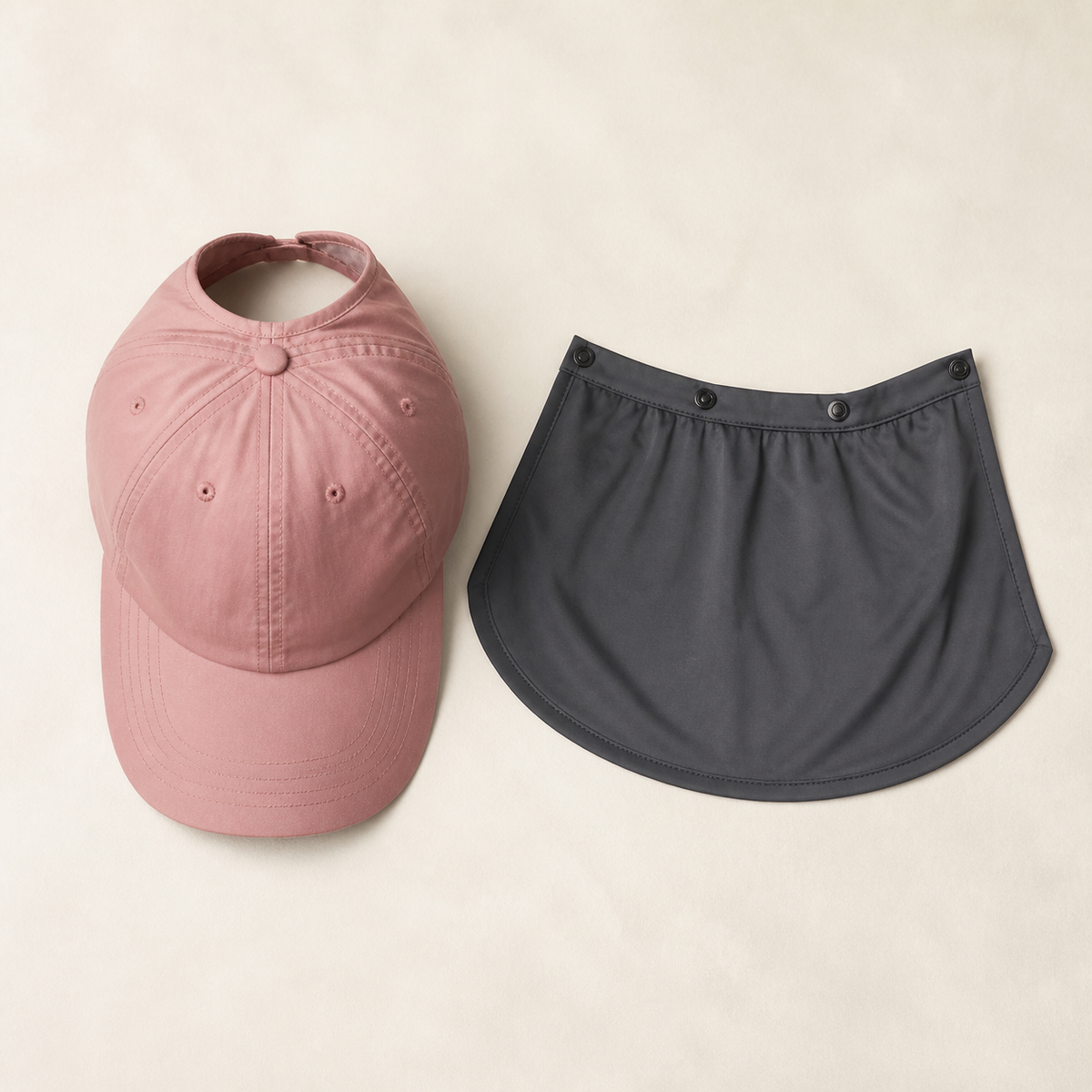 Pink ponytail cap and detachable dark gray drape laid separately
