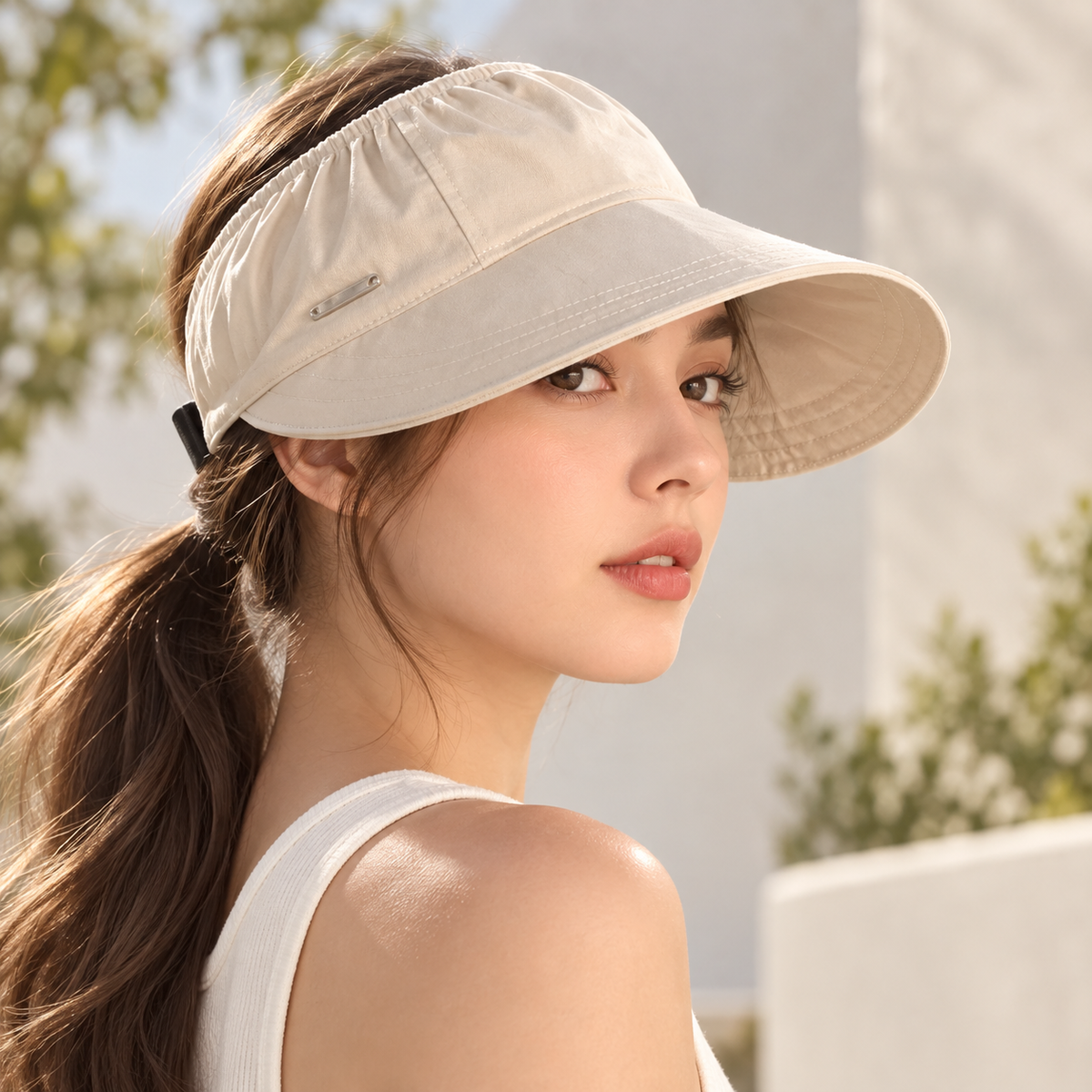 Beige ruched open-top sun visor worn with a ponytail